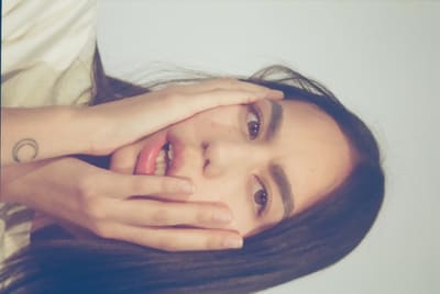Close-up, turned on its side, of a person with hands pressed to the face